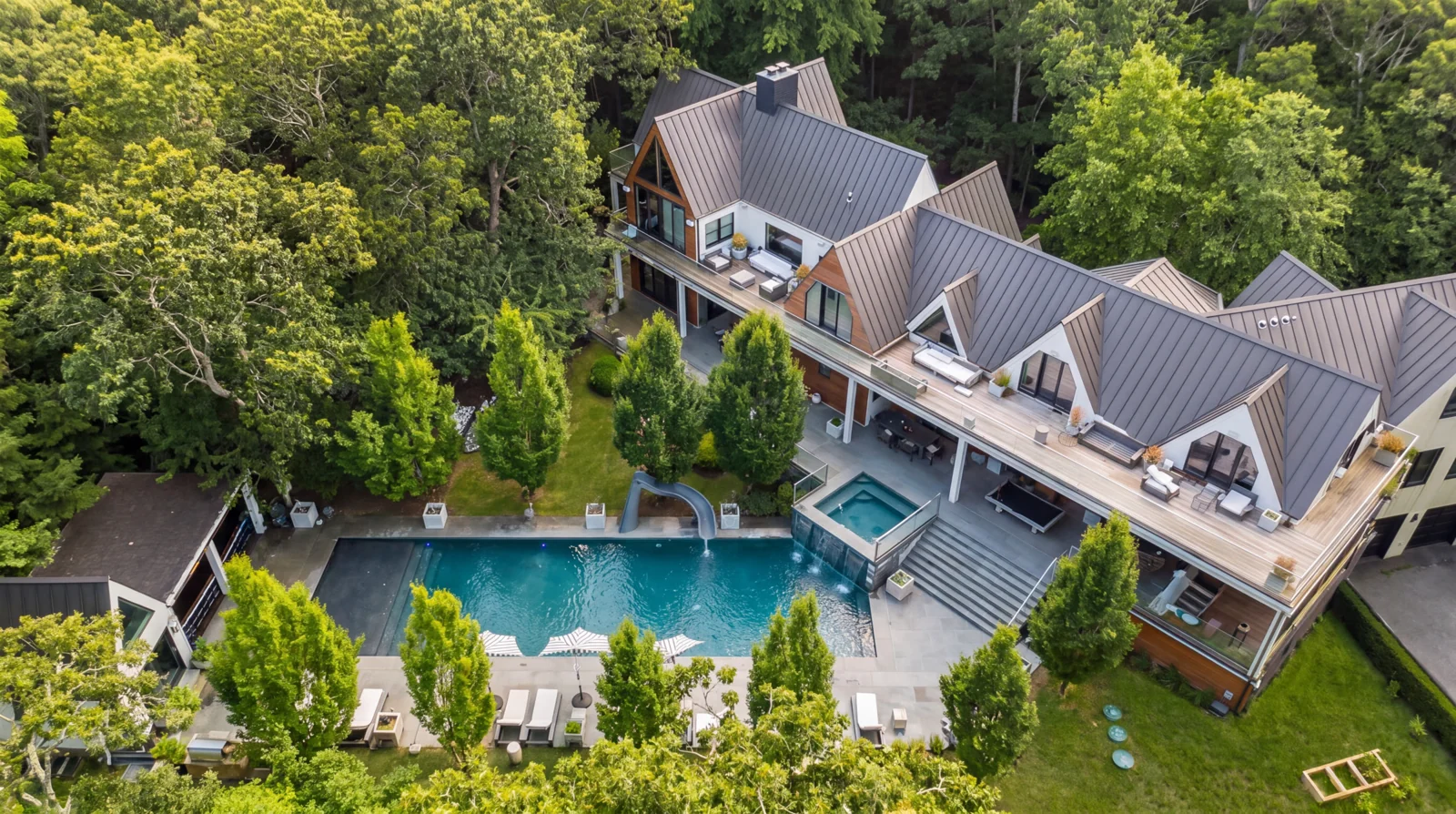 Aerial view of the pool terrace, spa and waterslide beside the main house